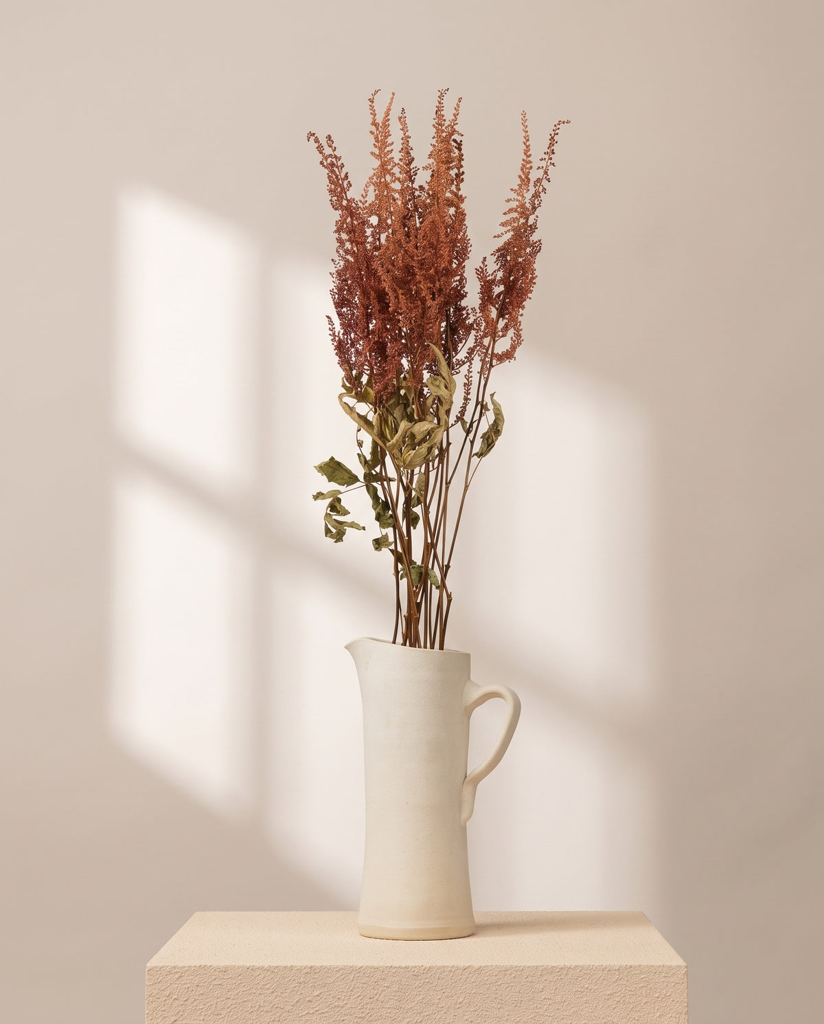 Astilbe preservada cereja numa jarra de cerâmica creme. Jarra não incluída.