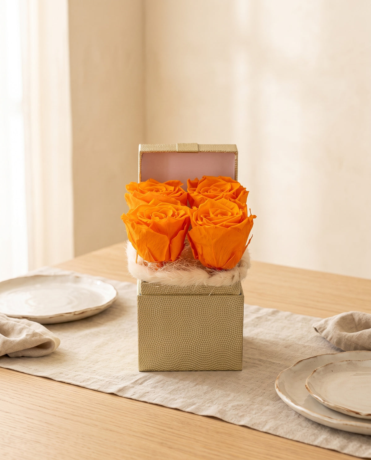 Centro de flores preservadas en naranja como centro en una mesa de comedor.