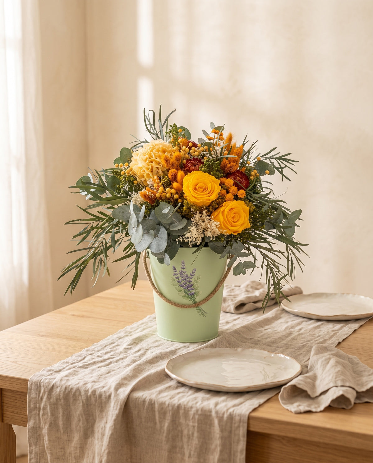 Centro de flores secas y preservadas en amarillo y naranja como centro en una mesa de comedor.