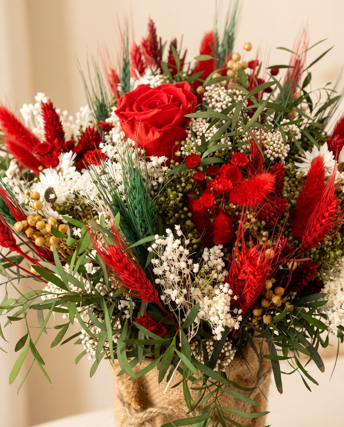 Detalle de cerca del centro de flores secas y preservadas en rojo.