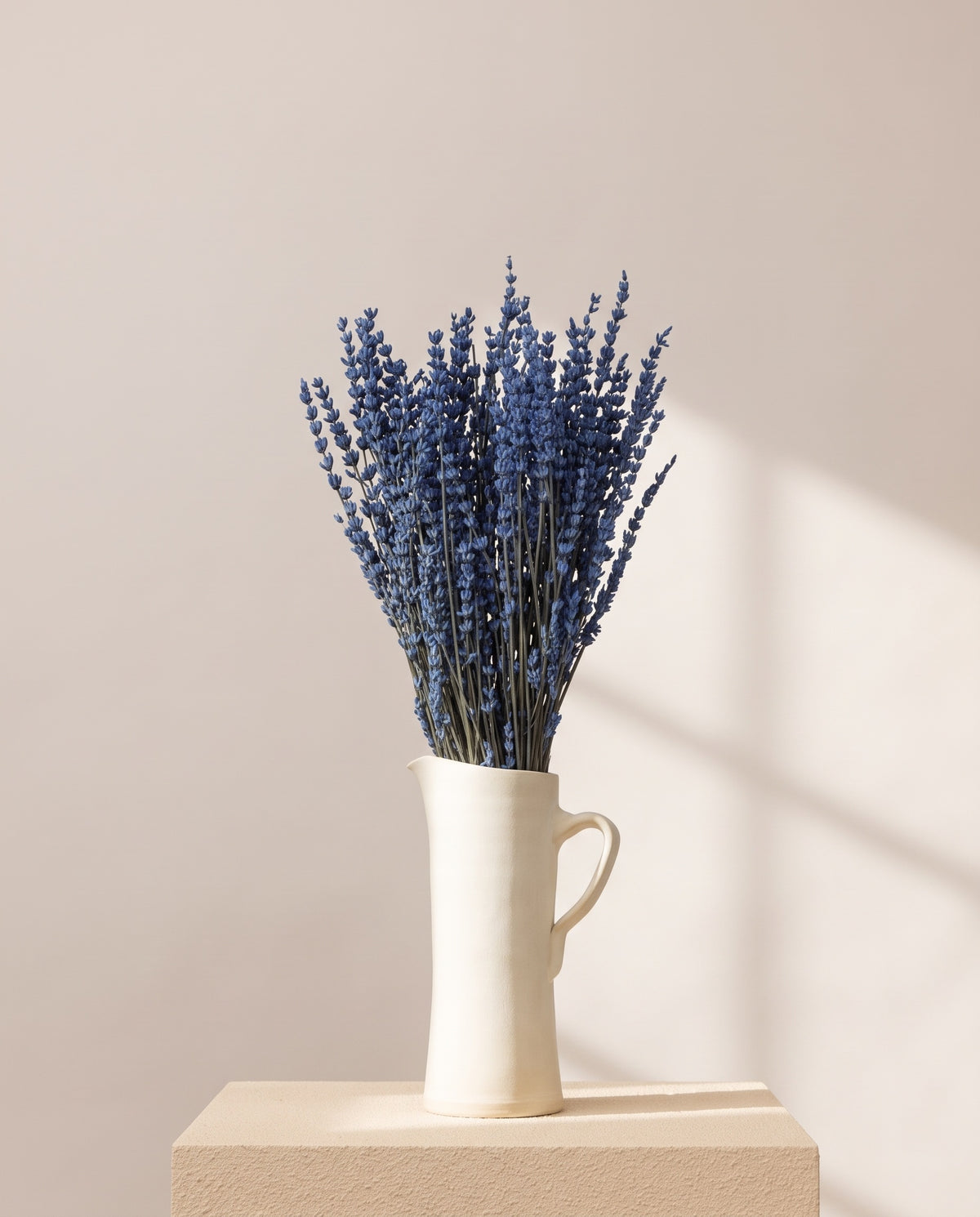 Lavanda preservada azul en una jarra de cerámica crema. Jarra no incluida.