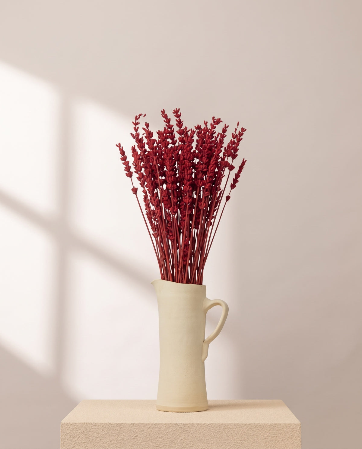 Lavanda preservada roja en una jarra de cerámica crema. Jarra no incluida.