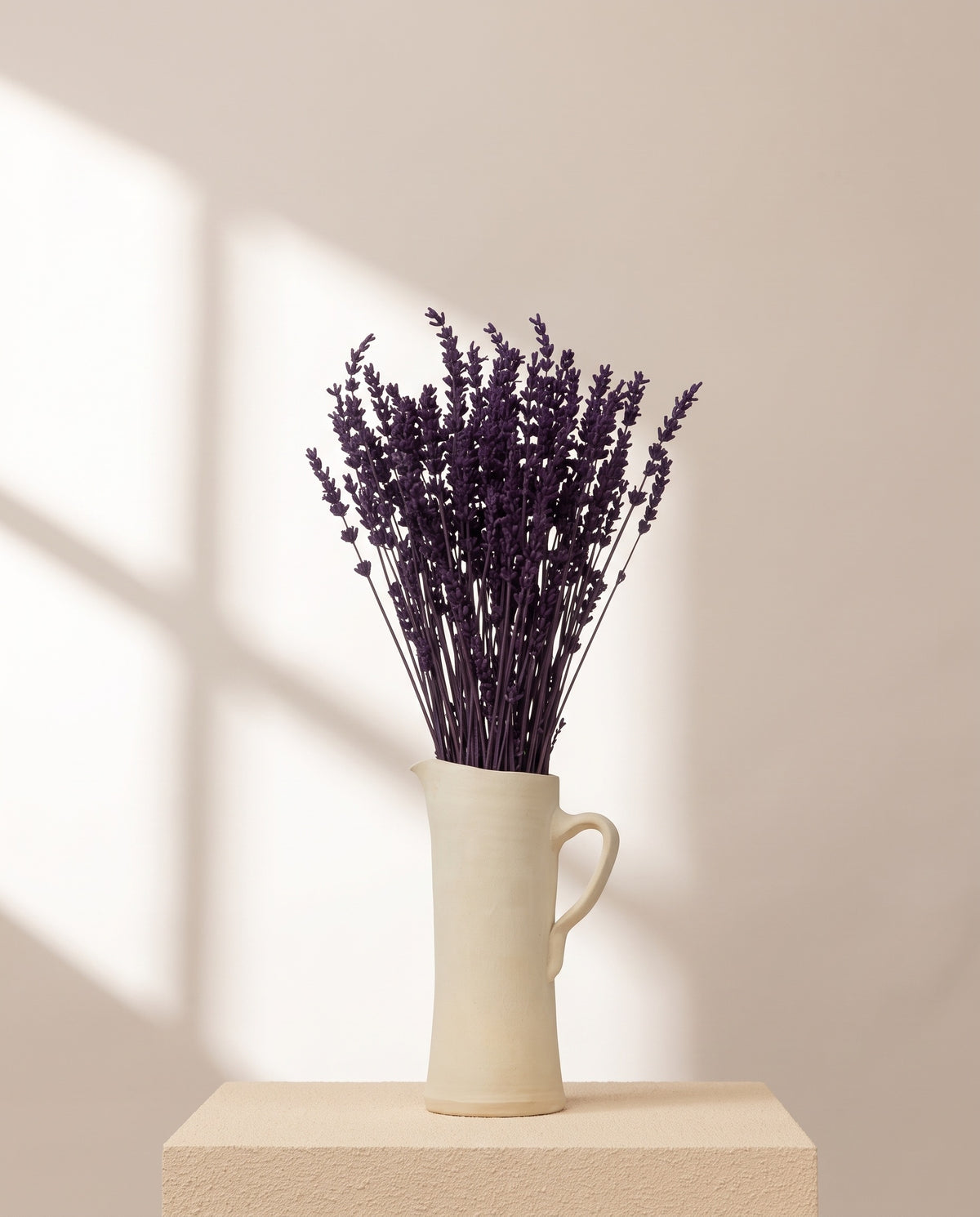 Lavanda seca morada en una jarra de cerámica crema. Jarra no incluida.