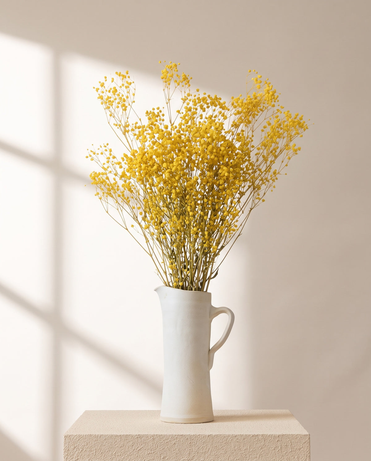 Paniculata preservada amarilla en una jarra de cerámica crema. Jarra no incluida.