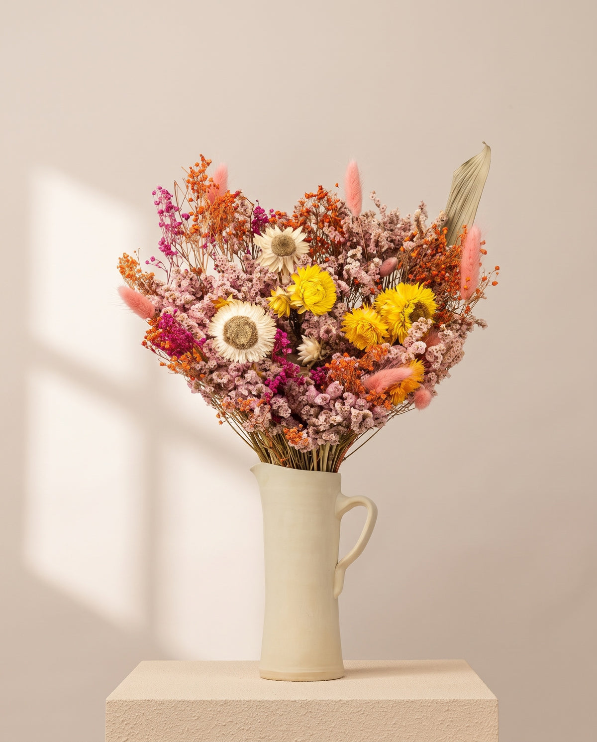 Ramo grande de flores secas multicolor numa jarra de cerâmica creme. Jarra não incluída.