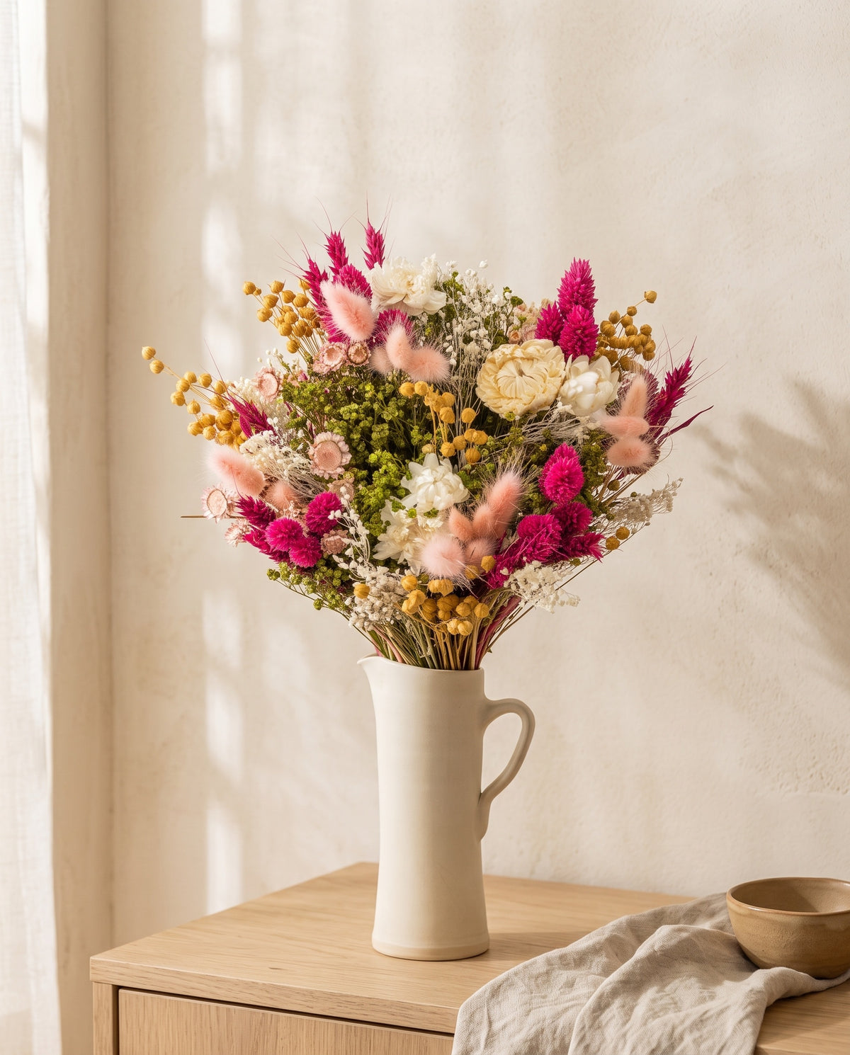 Ramo de flores secas em fúcsia com phalaris numa jarra sobre um aparador, ambiente de casa. Jarra não incluída.