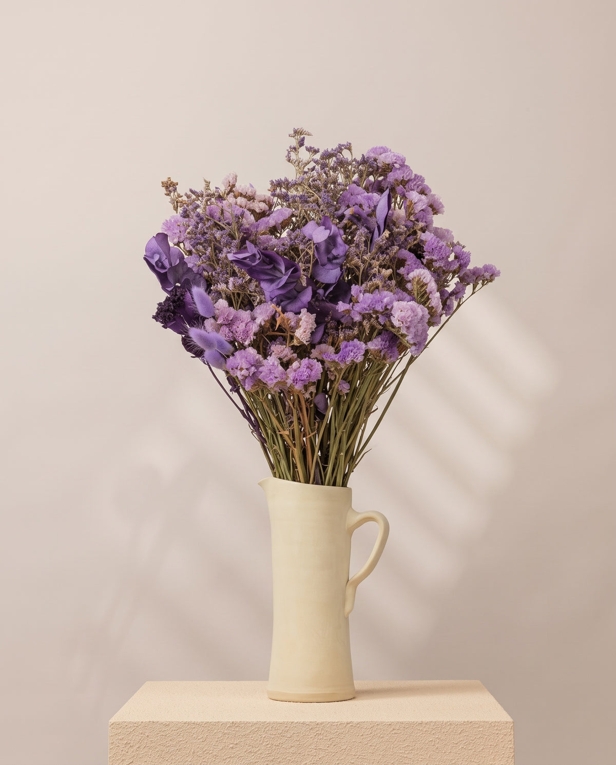 Ramo de flores secas em lavanda numa jarra de cerâmica creme. Jarra não incluída.