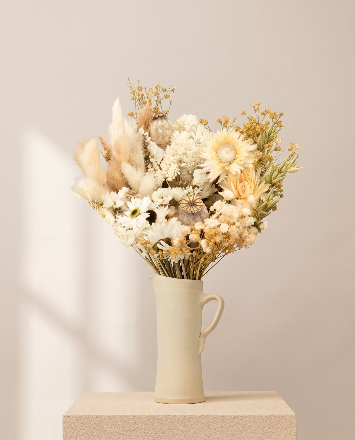 Ramo de flores secas e preservadas em branco com papaver numa jarra de cerâmica creme. Jarra não incluída.