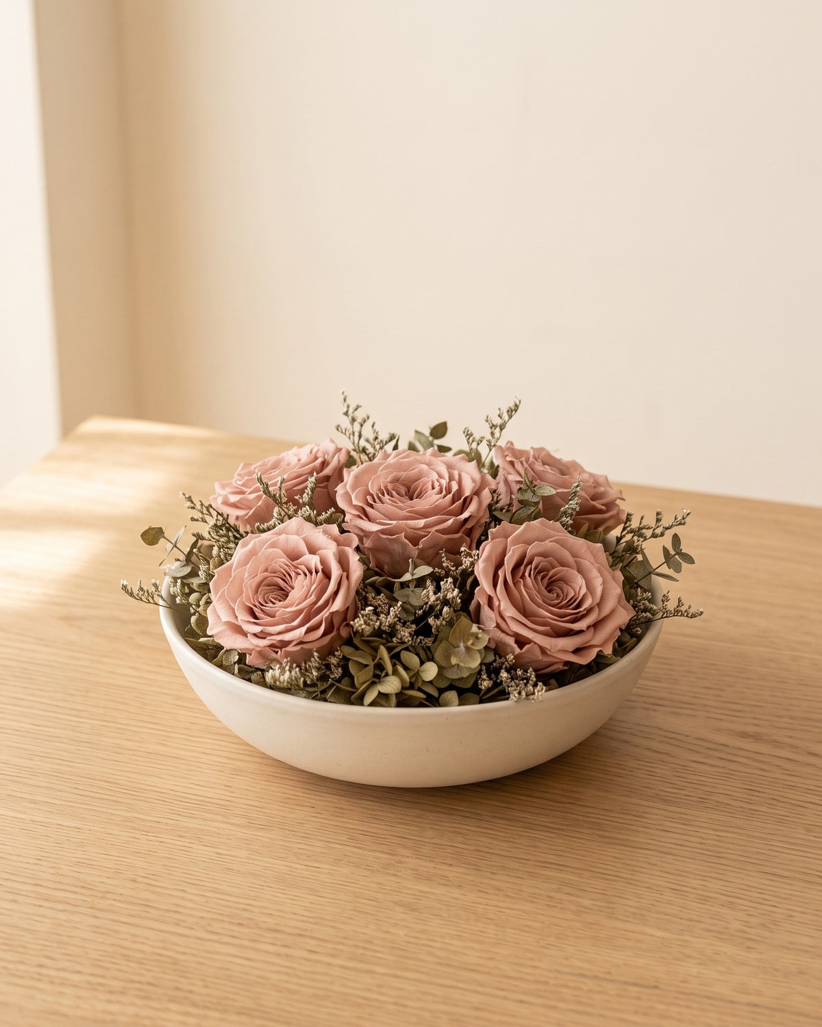Cabezas de rosa preservada rosa empolvado en un centro de mesa, ambientada. Cuenco no incluido.