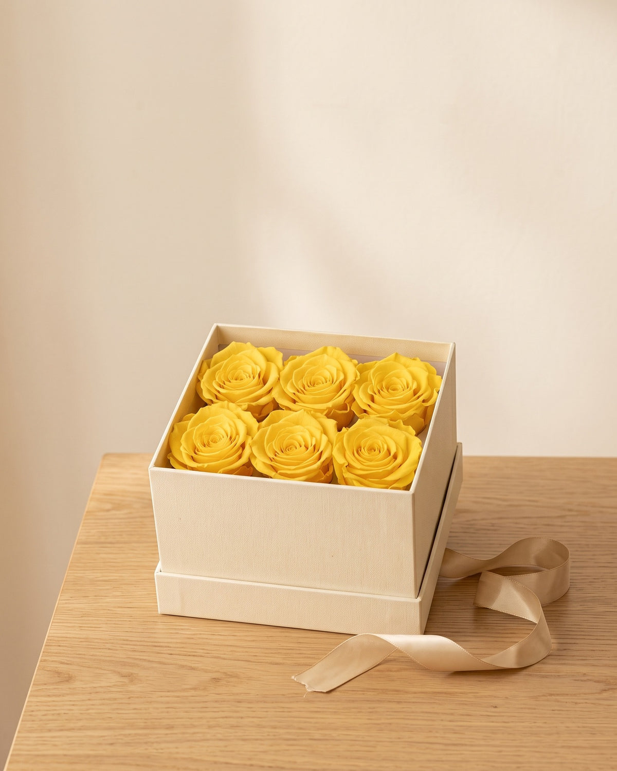Cabezas de rosa preservada amarilla en una caja de regalo, ambientada. Caja de regalo no incluida.