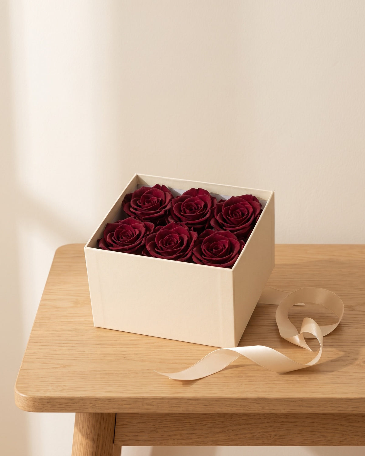 Cabezas de rosa preservada burdeos en una caja de regalo, ambientada. Caja de regalo no incluida.