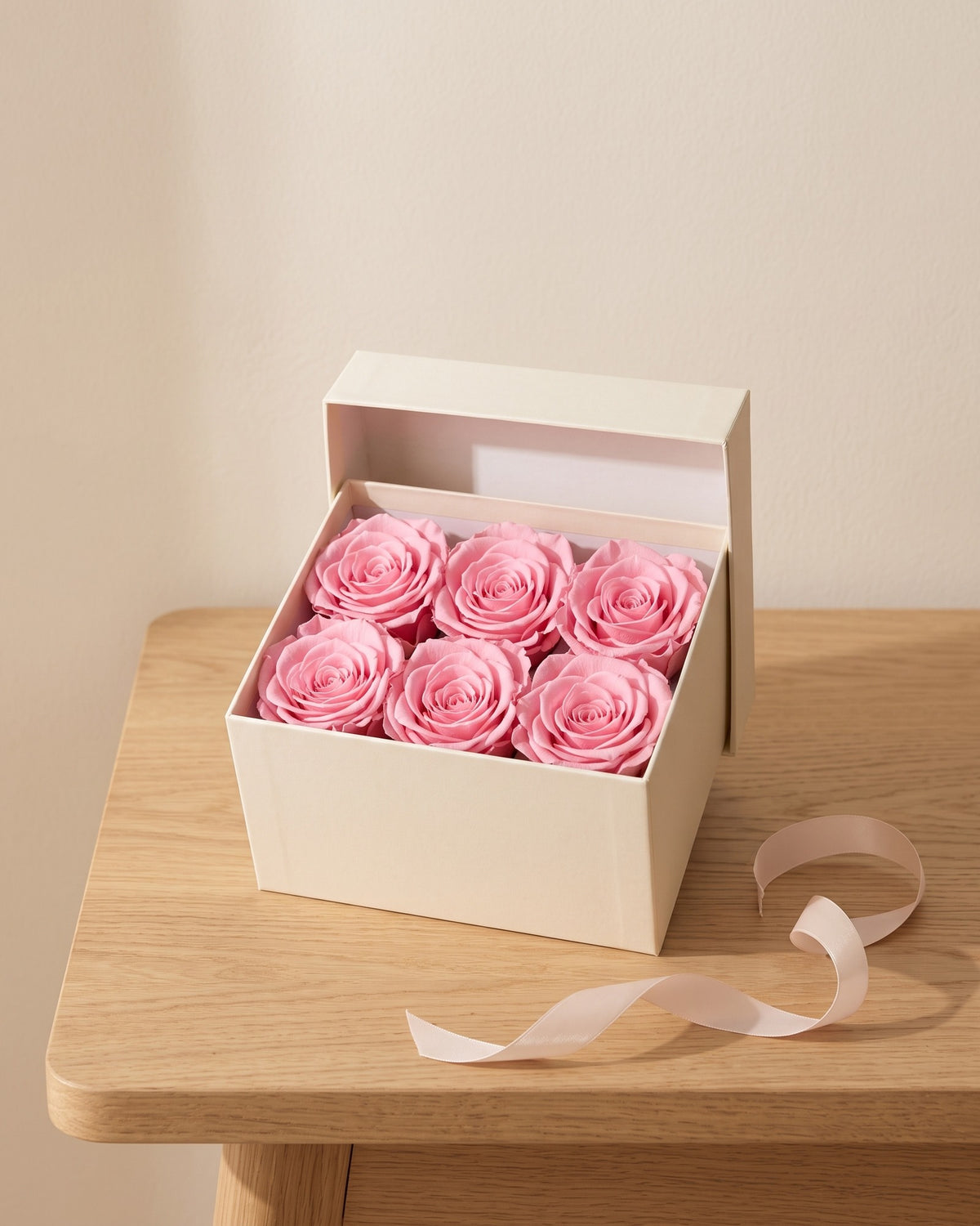 Cabezas de rosa preservada rosa en una caja de regalo, ambientada. Caja de regalo no incluida.