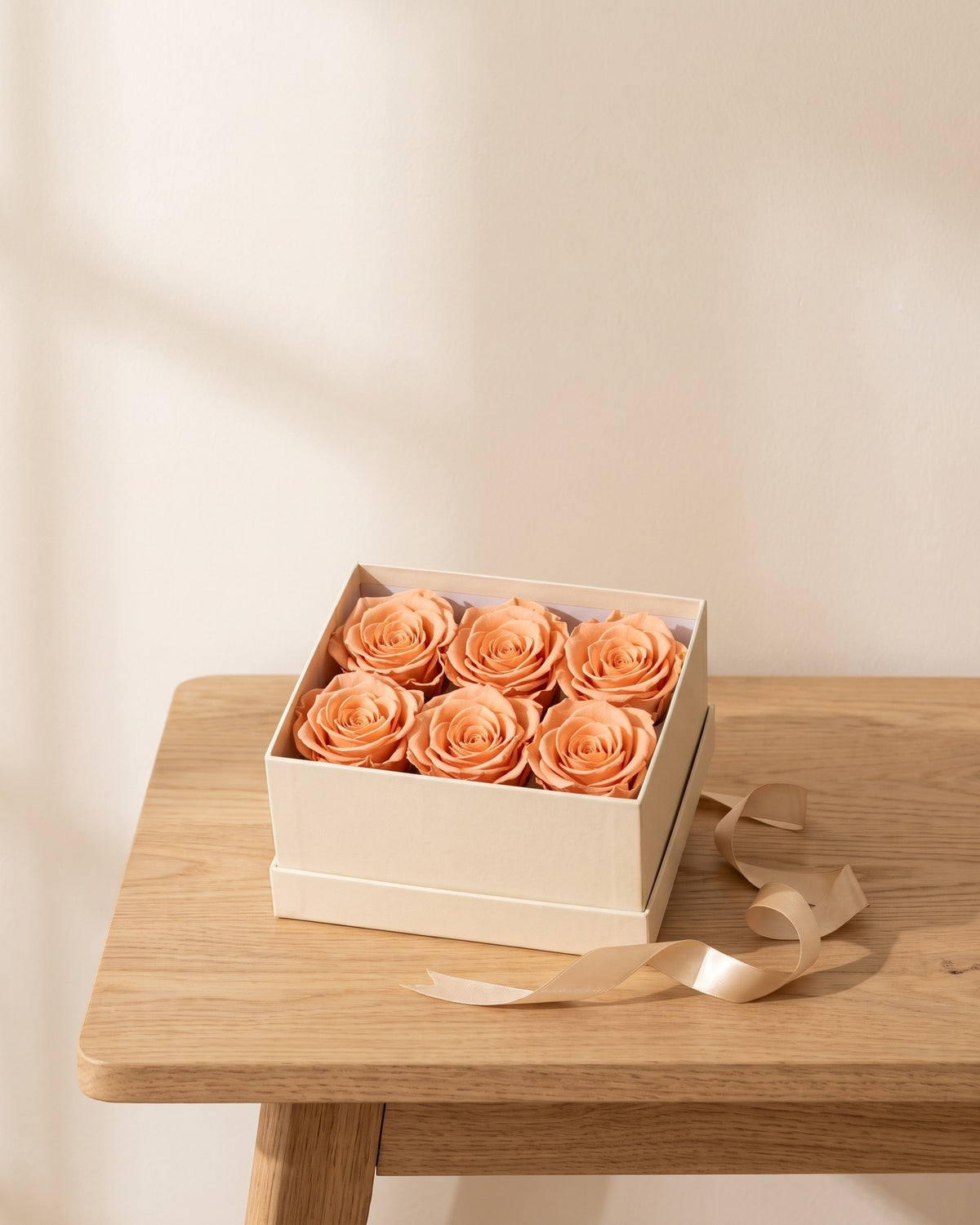 Cabezas de rosa preservada salmón en una caja de regalo, ambientada. Caja de regalo no incluida.