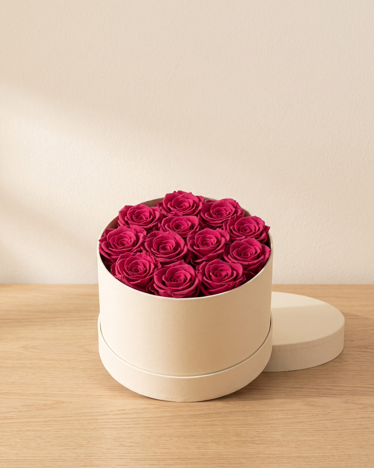 Cabezas de rosa preservada cereza en una caja redonda de regalo, ambientada. Caja de regalo no incluida.