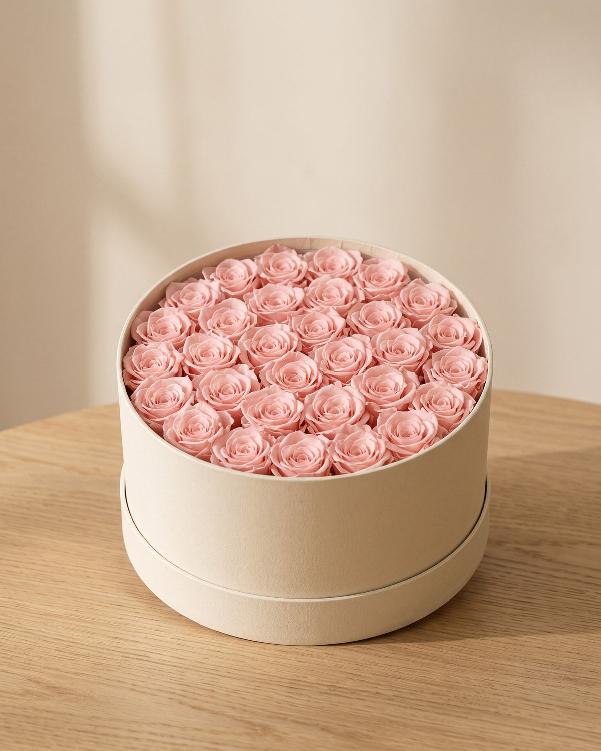 Cabezas de rosa preservada rosa clara en una caja redonda de regalo, ambientada. Caja de regalo no incluida.